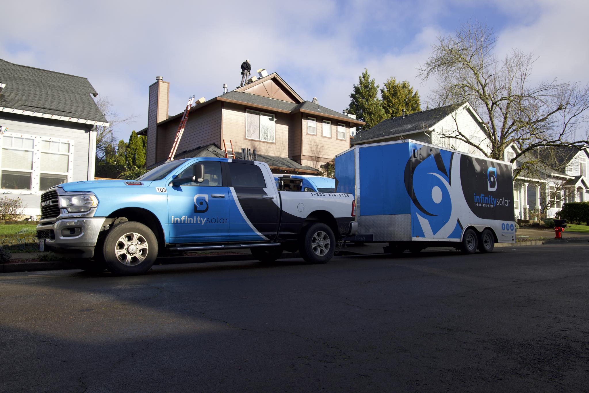 Infinity Solar branded truck and trailer at a job site