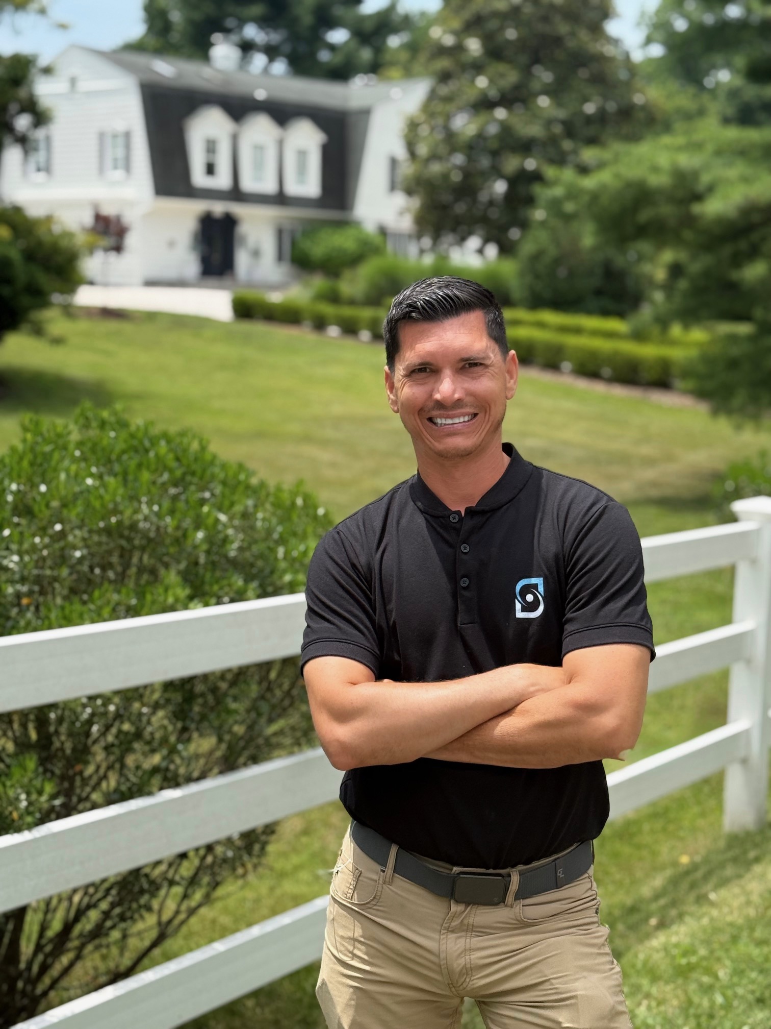 Jordan Gruzinski, Infinity Solar Maryland advisor, standing in front of a home with arms crossed
